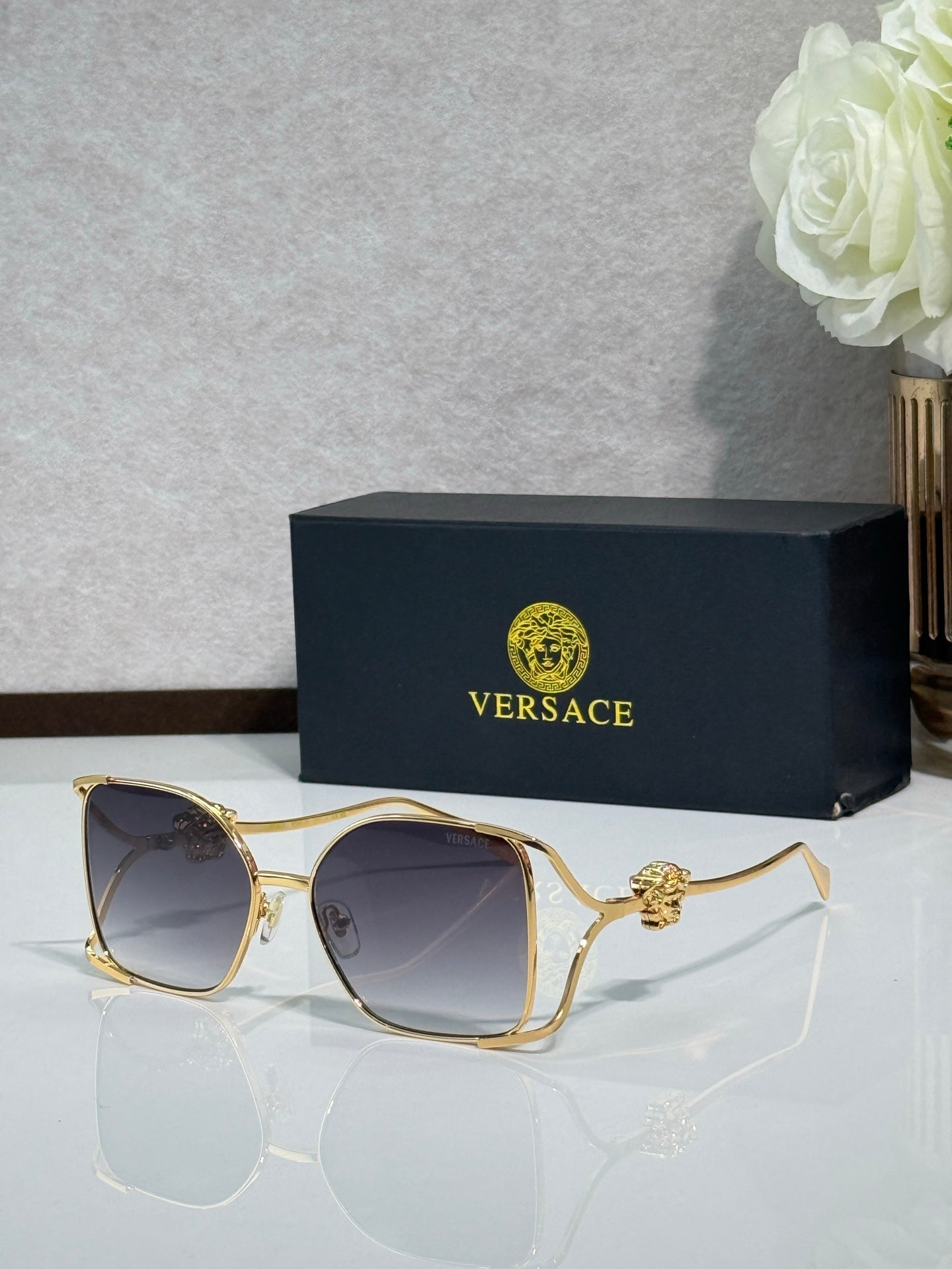 Versace sunglasses with gold metal frame and dark gray lenses