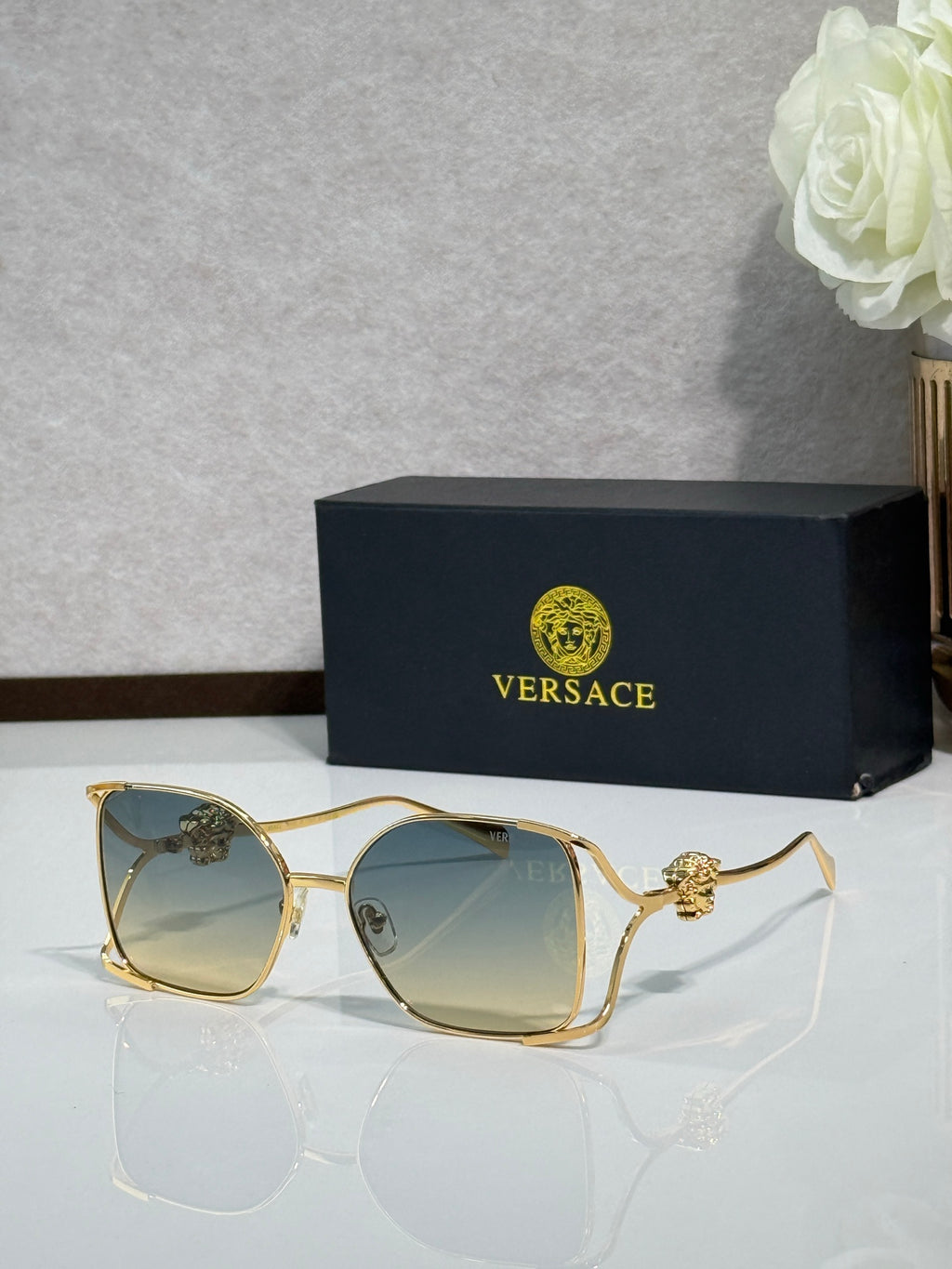 Versace sunglasses with gold metal frame and tinted dark lenses
