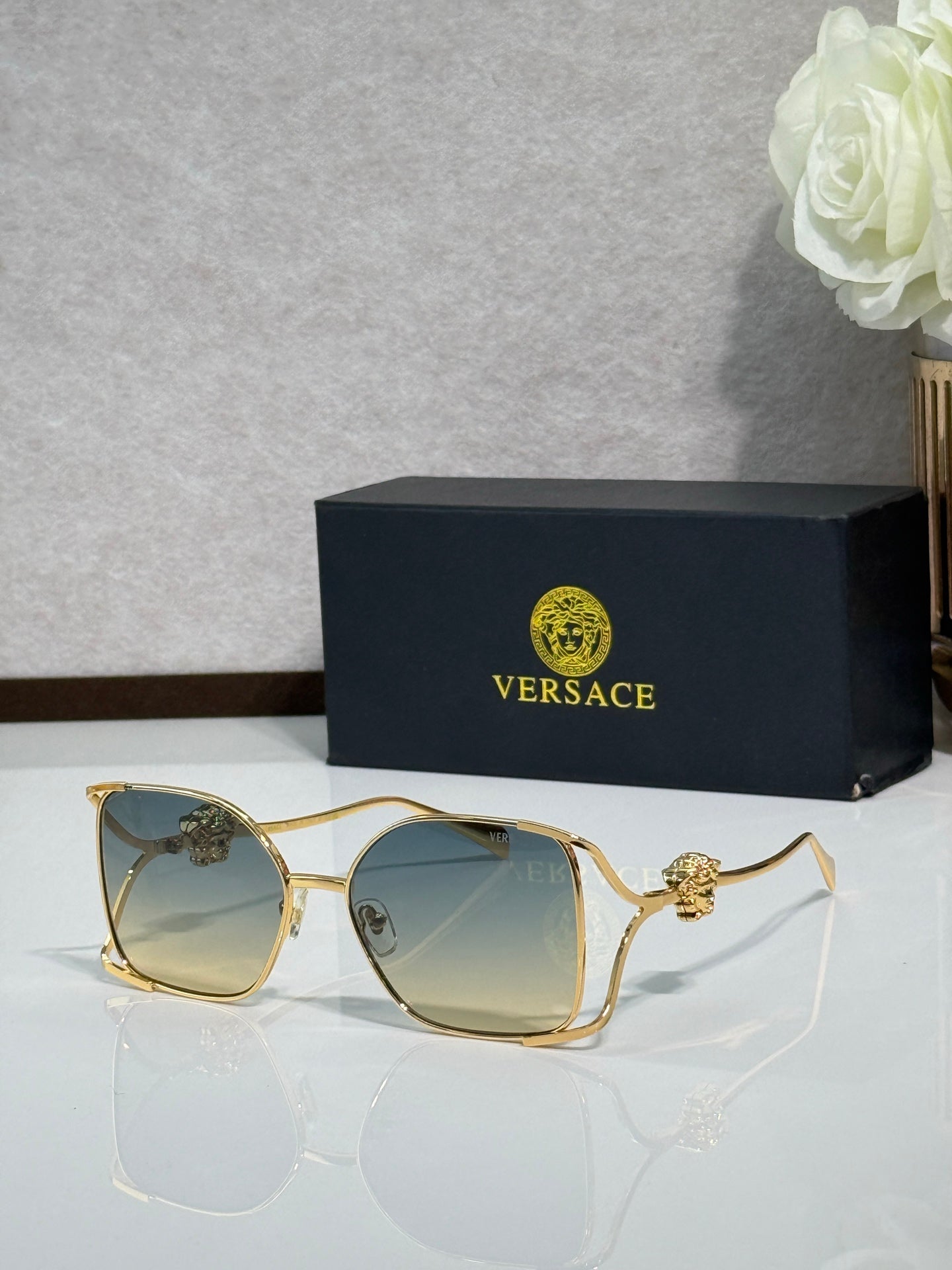 Versace sunglasses with gold metal frame and tinted dark lenses