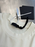 Cream crew-neck T-shirt with ribbed collar and hanging tags