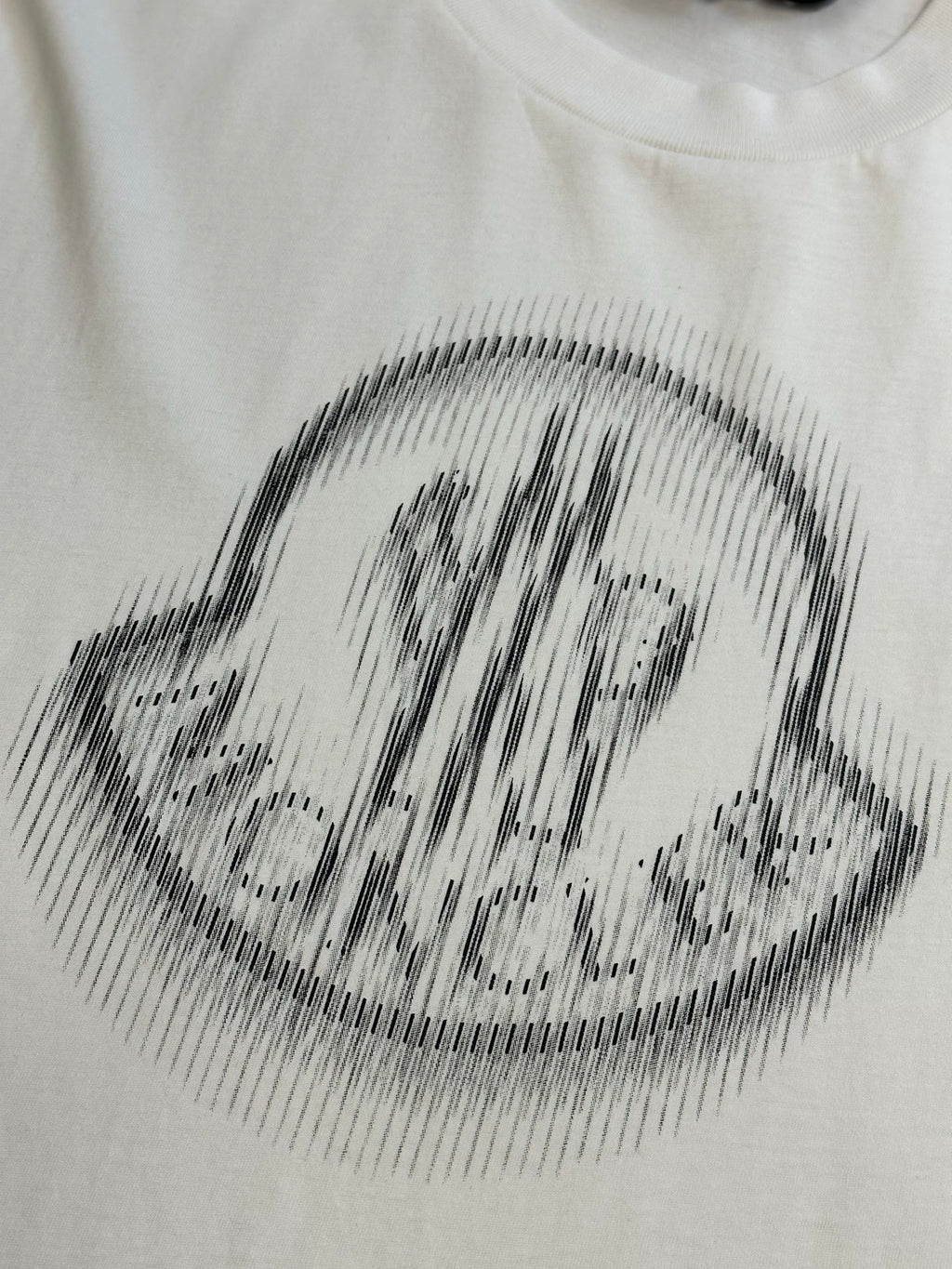 Cream T-shirt with black halftone crest logo print