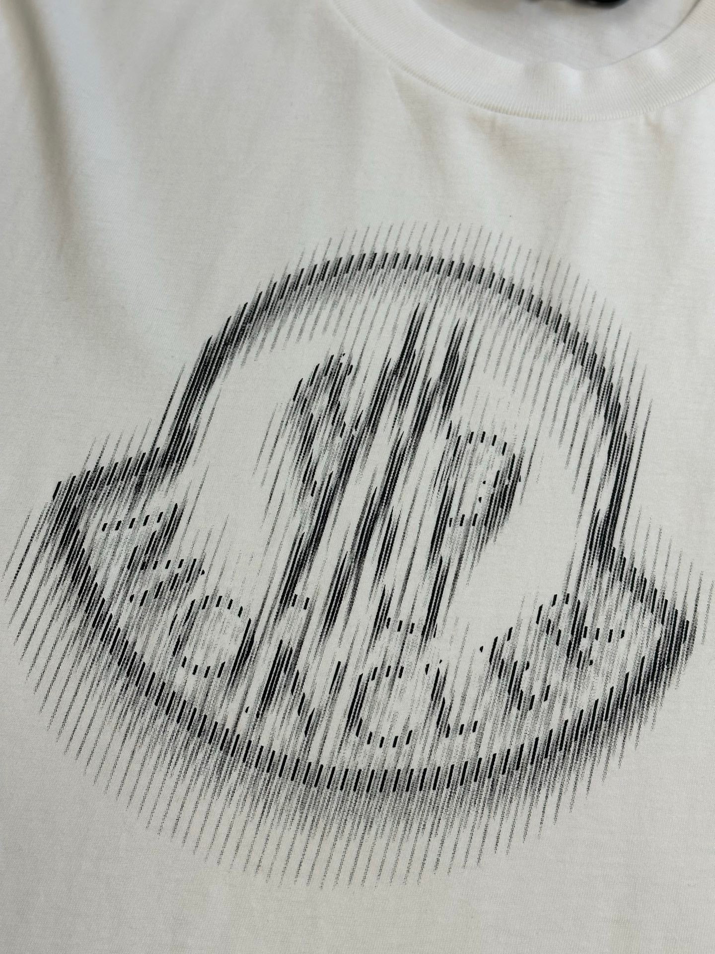 Cream T-shirt with black halftone crest logo print