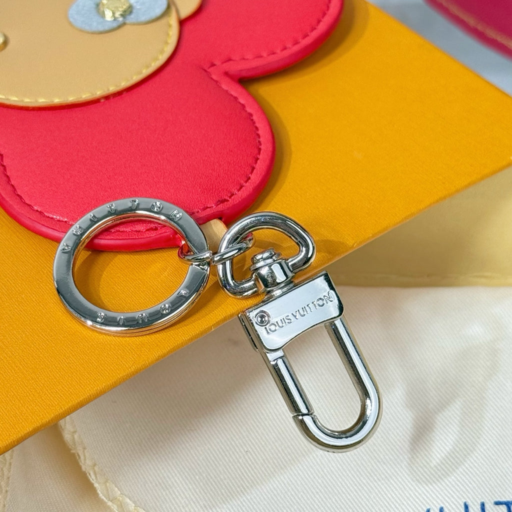 Silver metal keyring and lobster clasp attached to red leather flower charm.