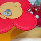 Close-up red leather flower charm with beige patch and silver heart stud.
