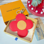 Red leather flower bag charm with beige center and silver lobster clasp.