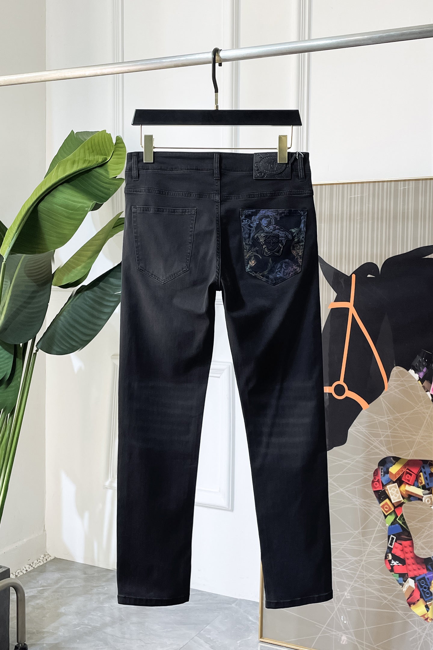 Dark denim jeans with embroidered logo graphic panel on front pocket