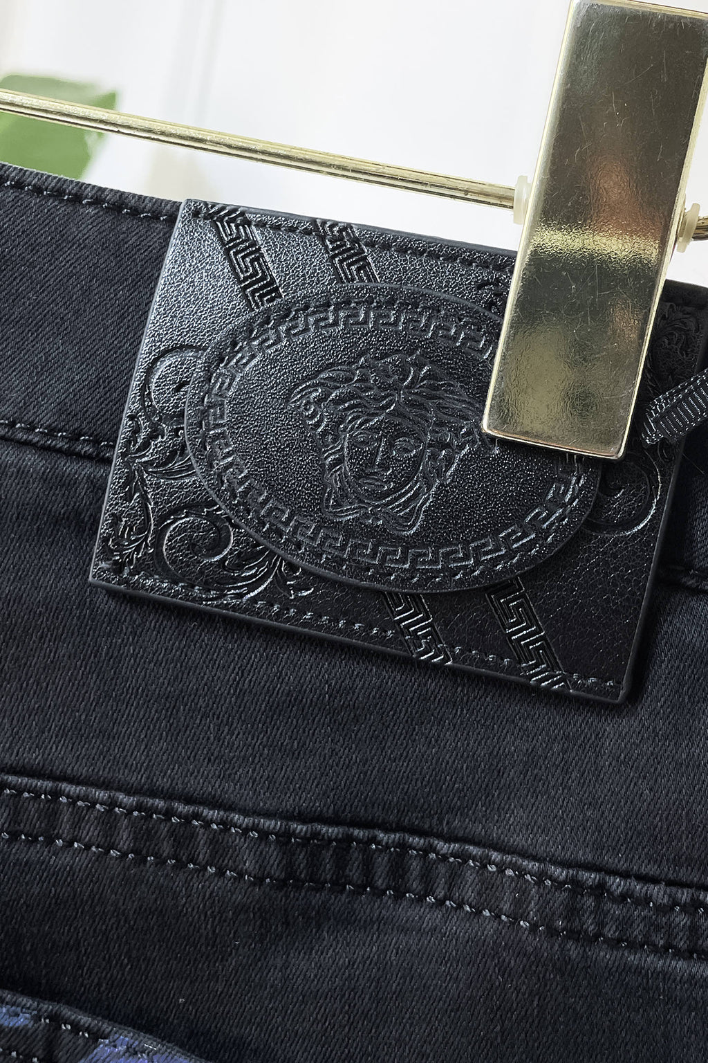 Dark denim jeans pocket lining with engraved medallion-style logo patch