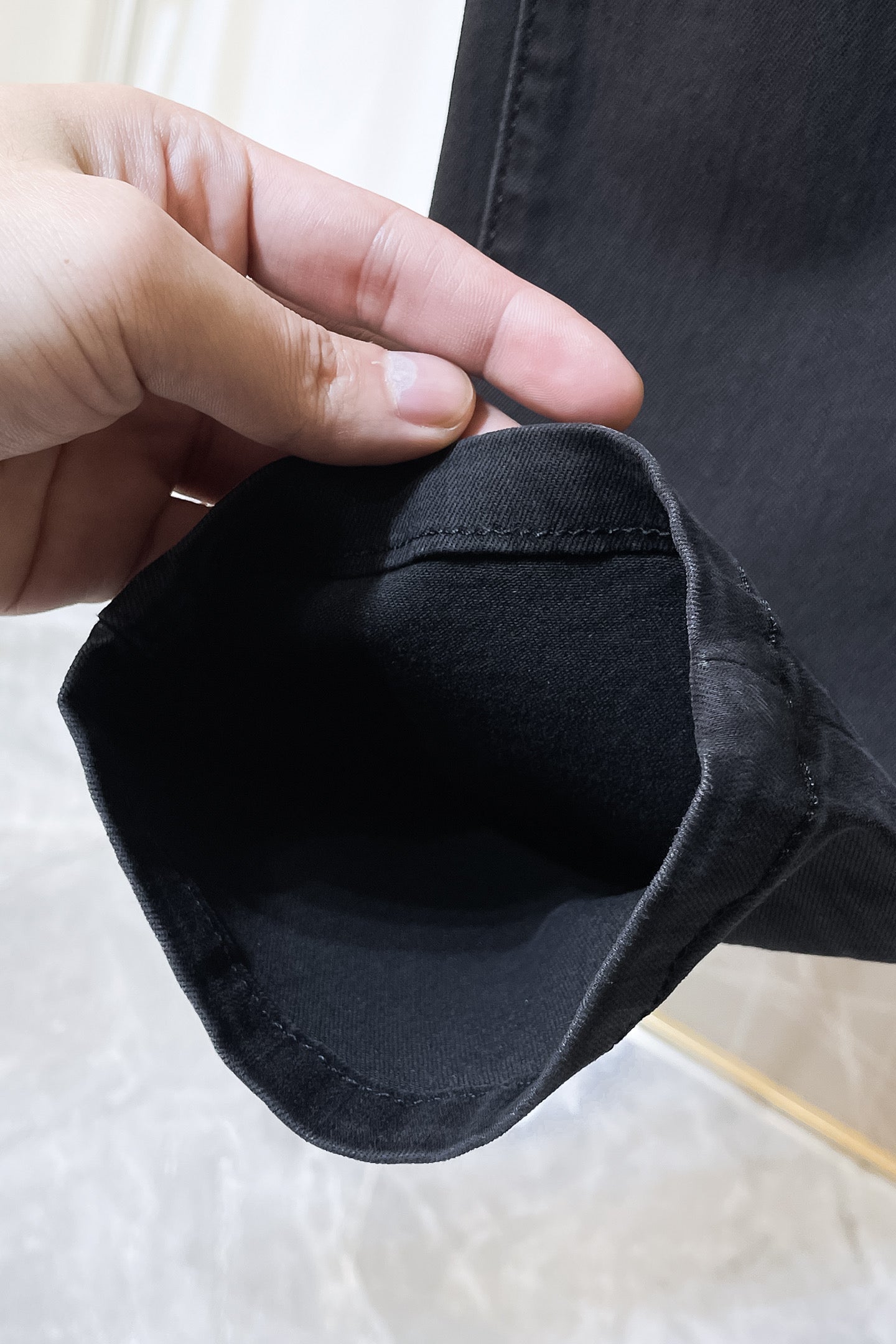 Dark denim jeans cuff hem with visible stitching and folded edge