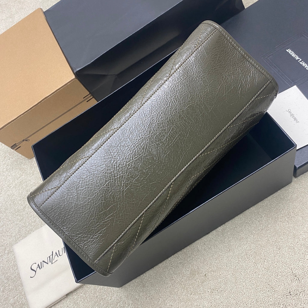 Long tote bag in dark green pebbled leather with gold chain strap and curved edges