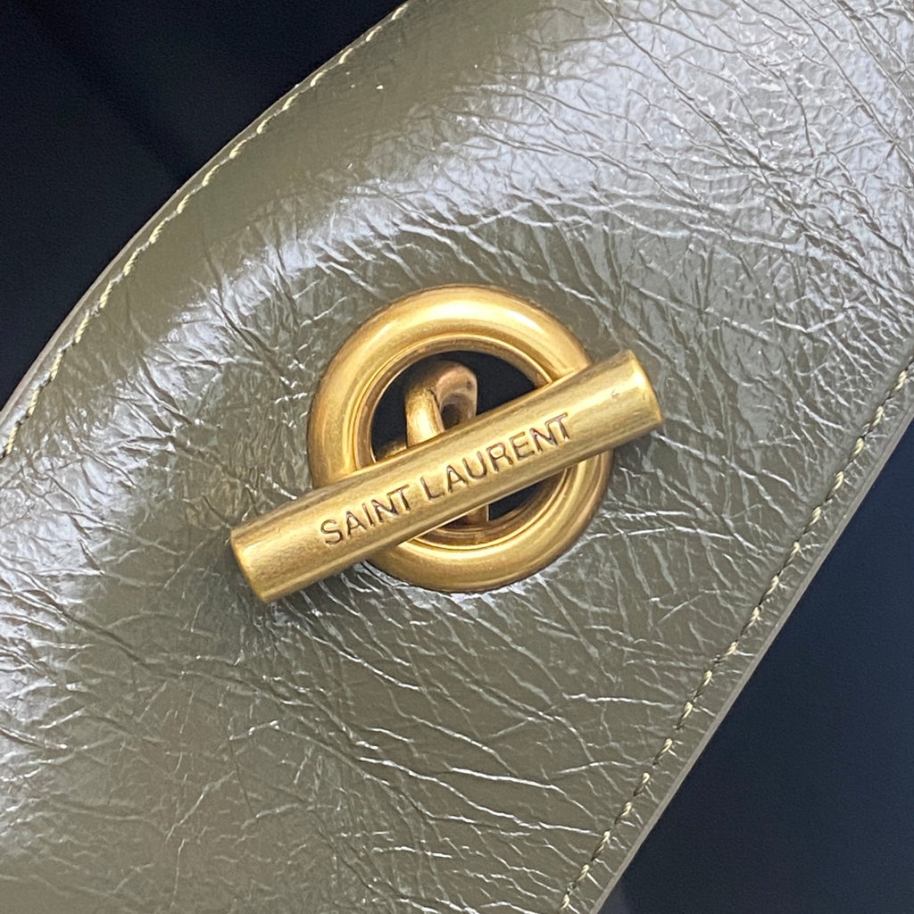 Gold Saint Laurent logo push-lock on dark green pebbled leather bag