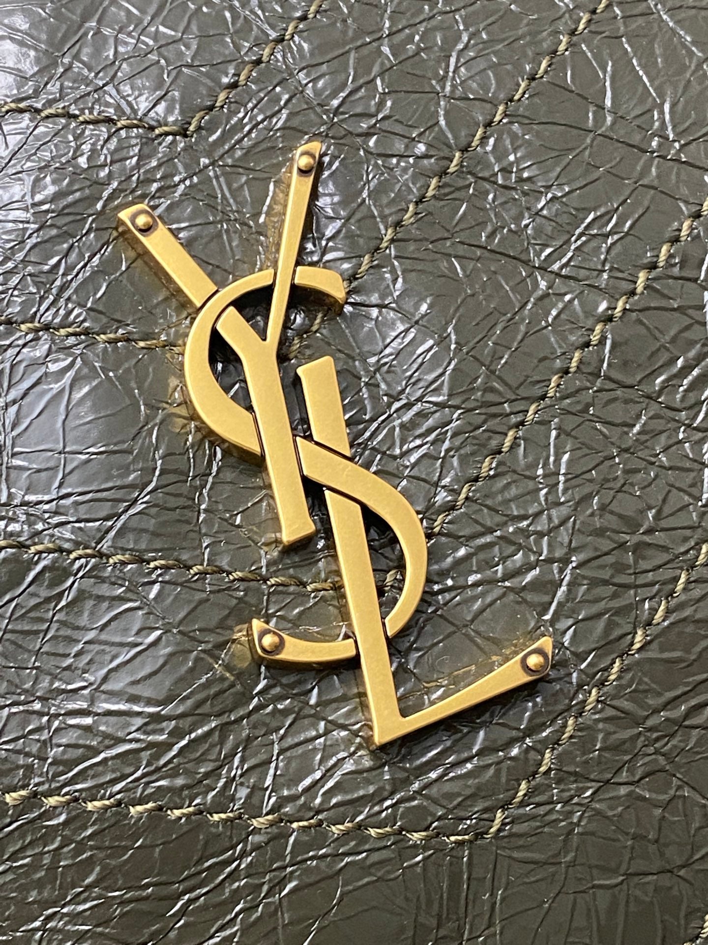 Gold YSL monogram pendant on dark green textured leather