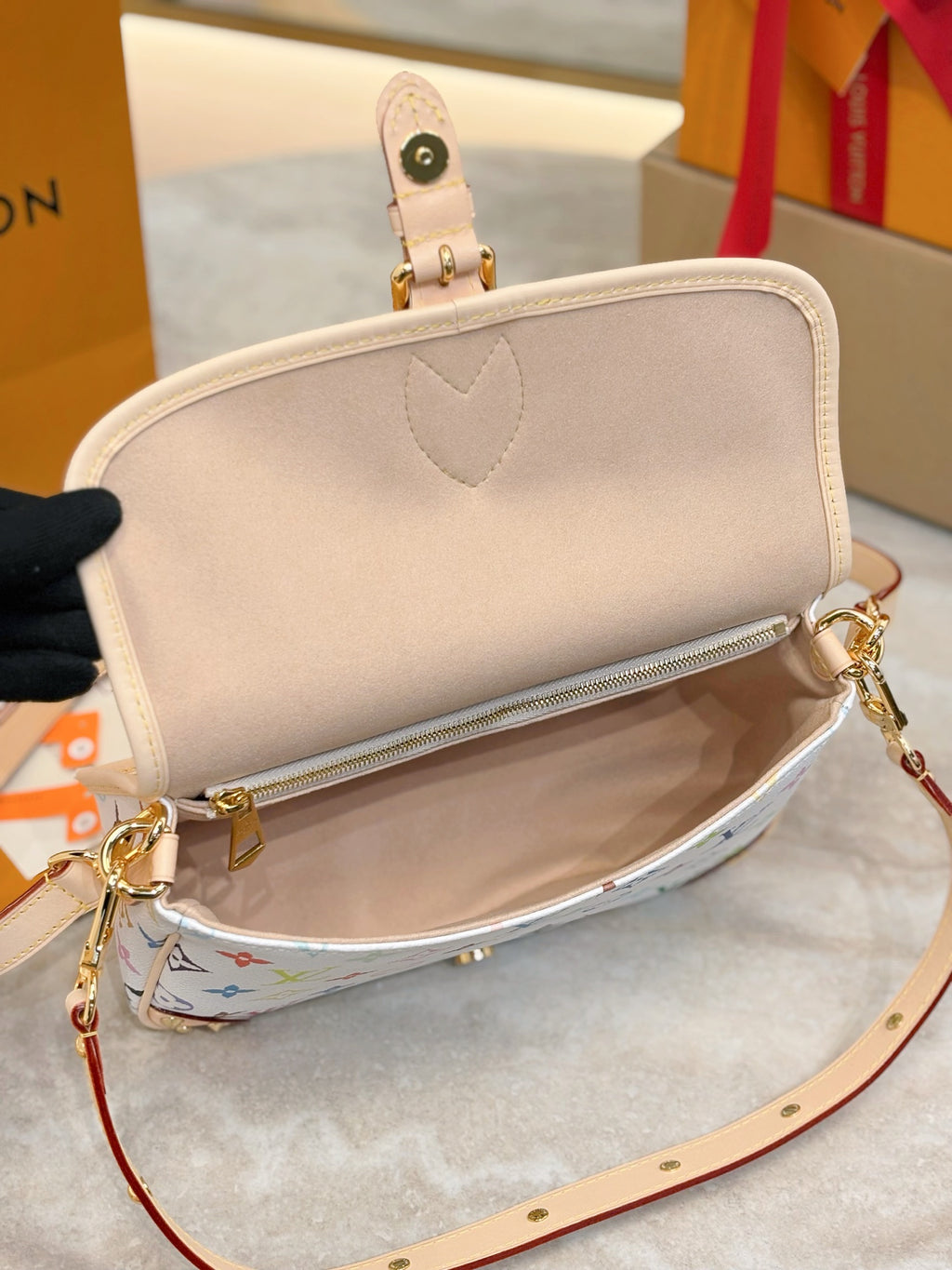 Louis Vuitton crossbody bag interior view with beige lining and zip pocket opening
