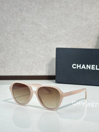 Chanel sunglasses with light pink frames and warm taupe tinted lenses.