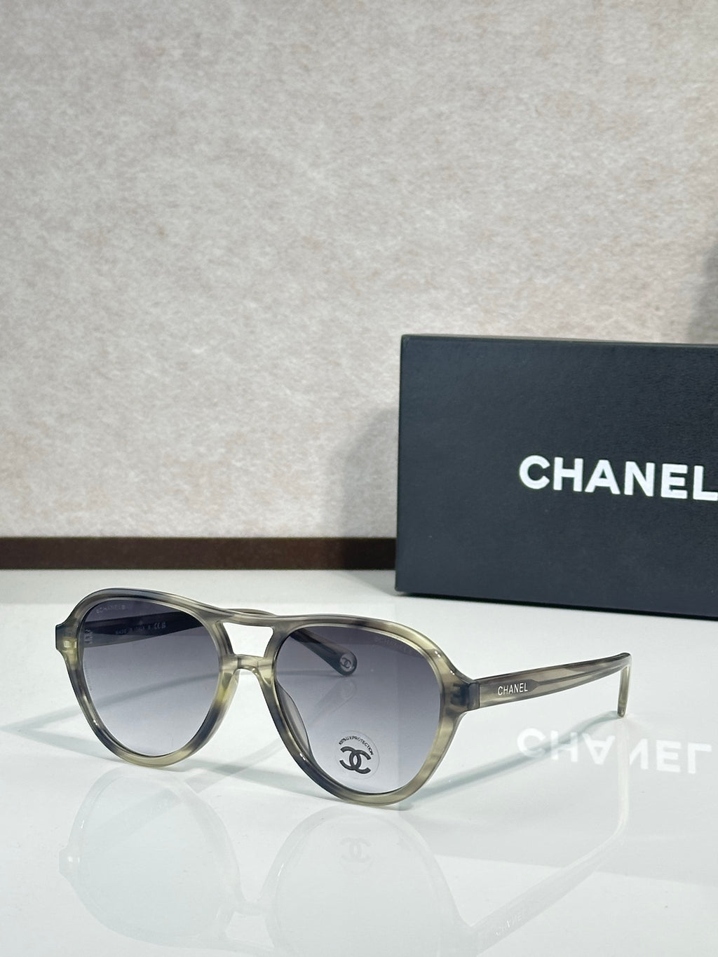 Chanel sunglasses with translucent olive-tinted frames and clear gray lenses.
