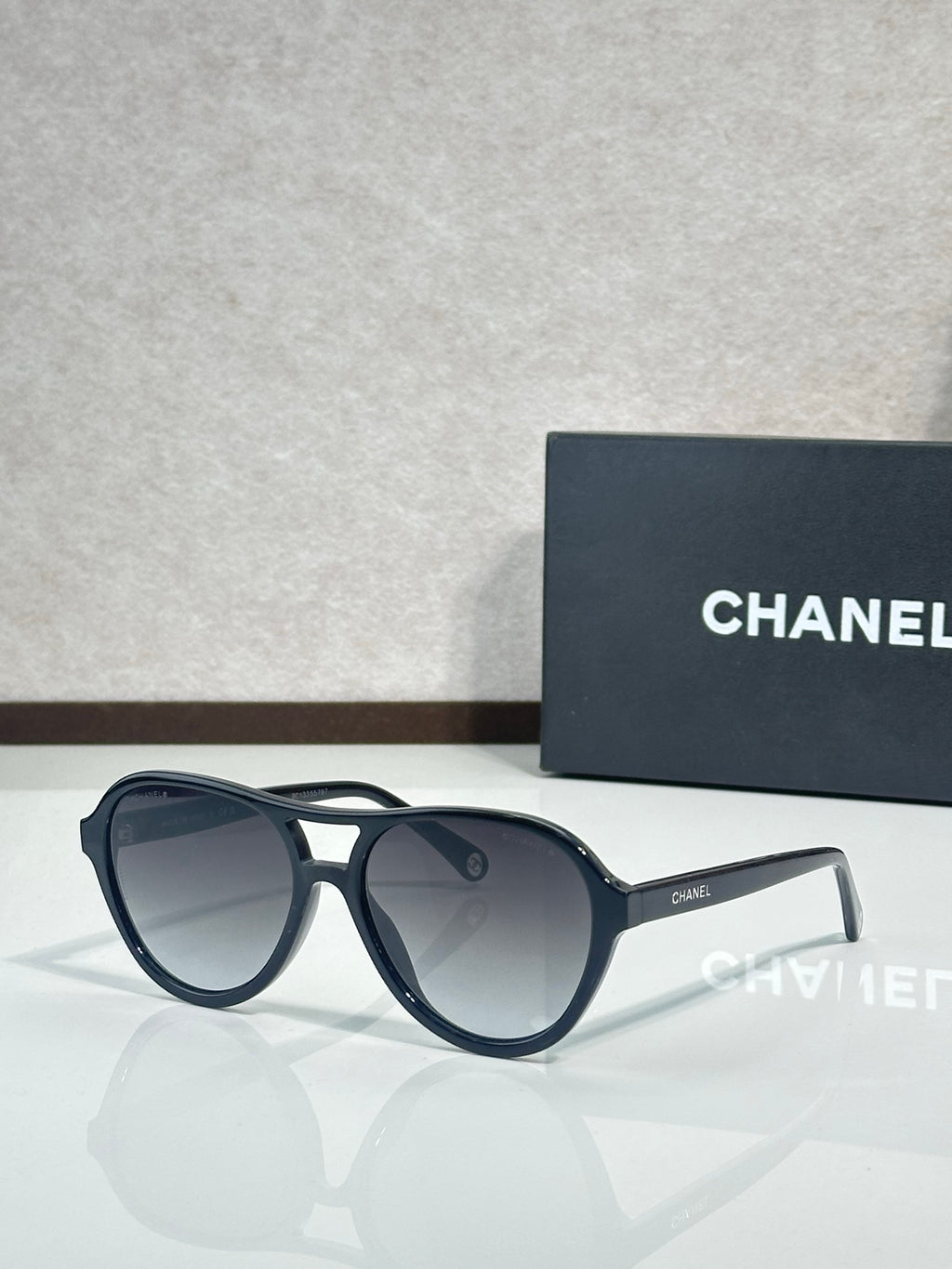 Chanel sunglasses with dark frames and smoky gray tinted lenses.