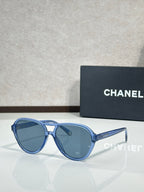 Chanel sunglasses with light blue frames and blue tinted lenses.