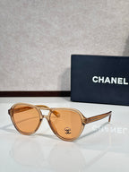 Chanel sunglasses with amber frames and amber tinted lenses.