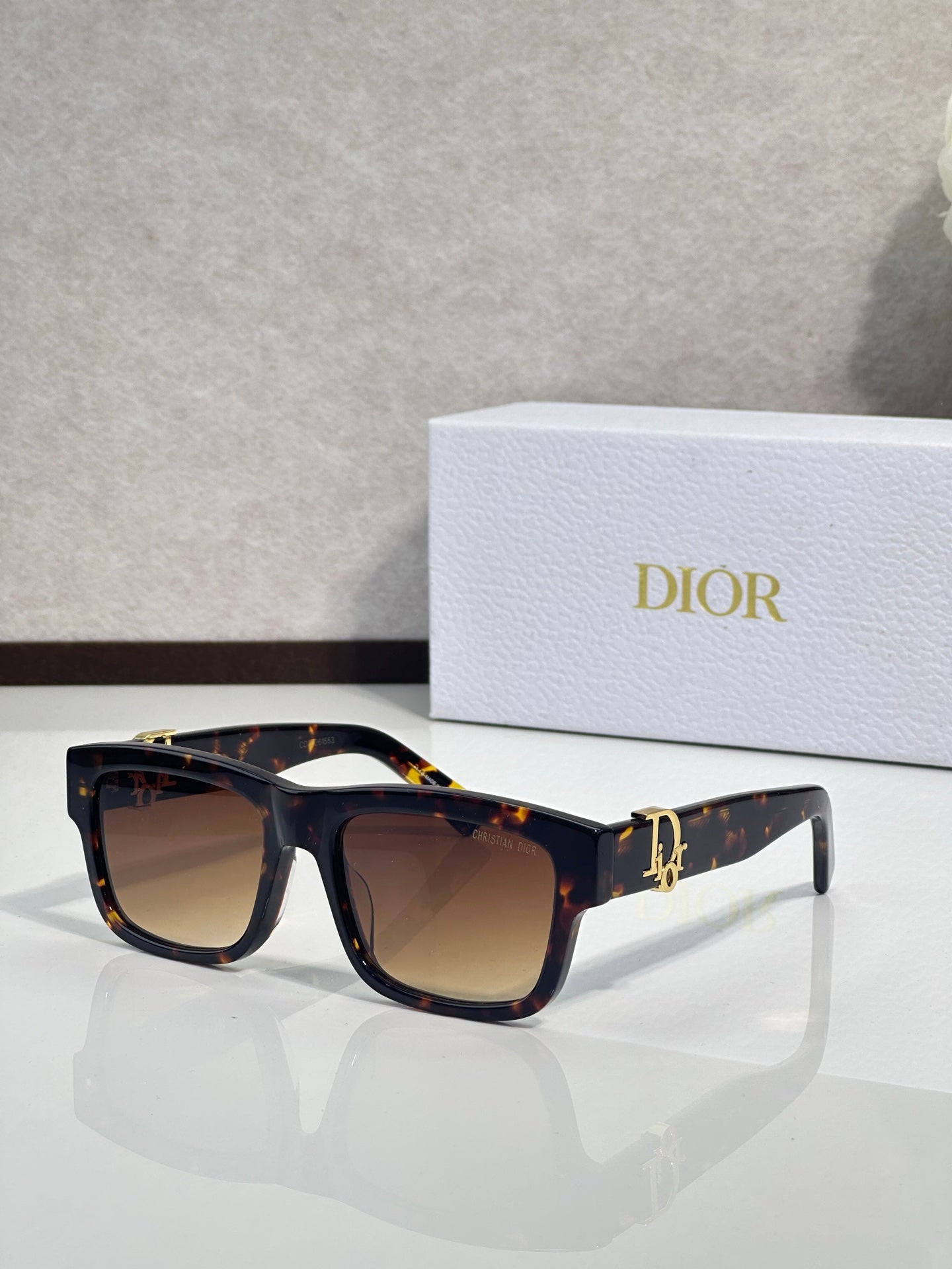 Tortoiseshell square sunglasses with gradient lenses and gold logo detail on temples.