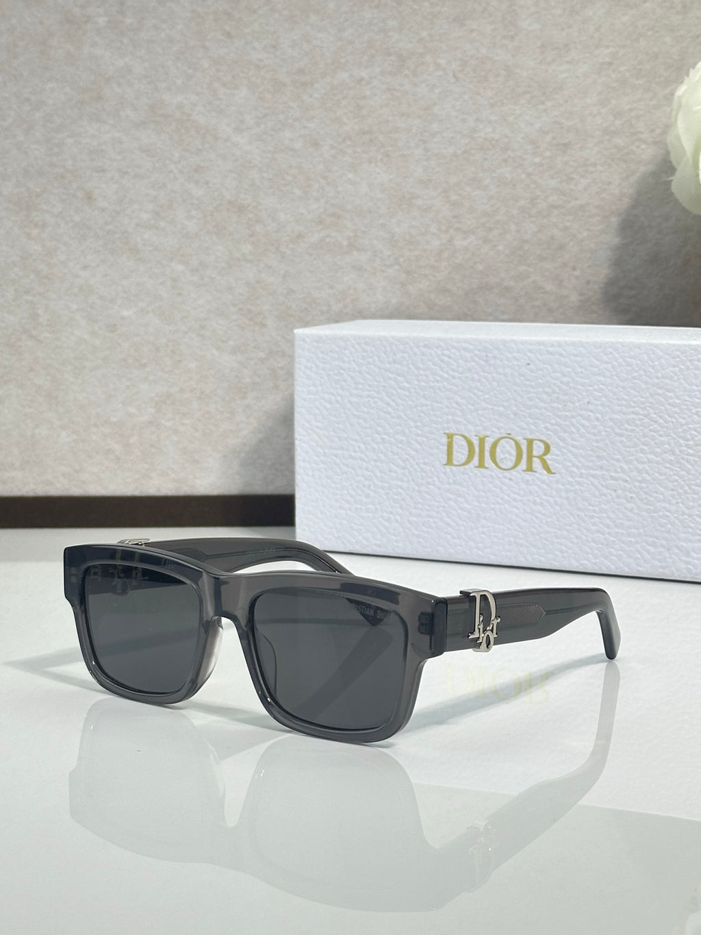 Gray square sunglasses with dark lenses and gold logo bar at the center.