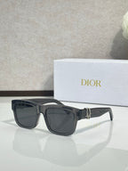 Gray square sunglasses with dark lenses and gold logo bar at the center.