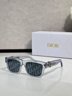 Clear gray square sunglasses with dark monogram lenses and gold logo bar.