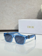 Blue square sunglasses with dark monogram lenses and gold logo detail on temples.