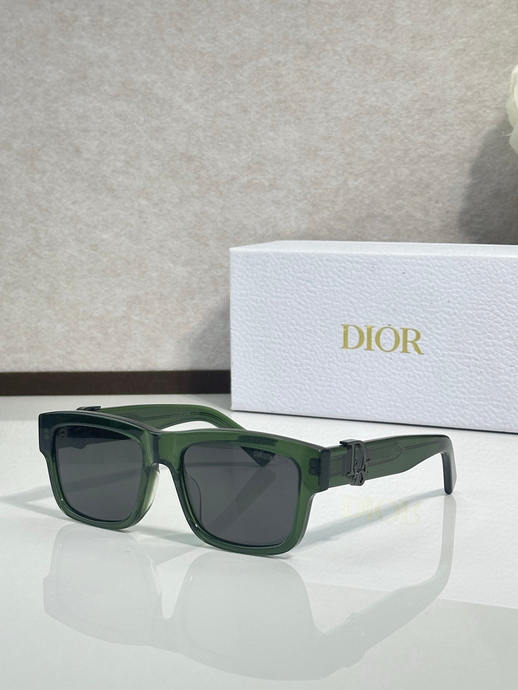 Dark green square sunglasses with dark lenses and gold logo detail on temples.