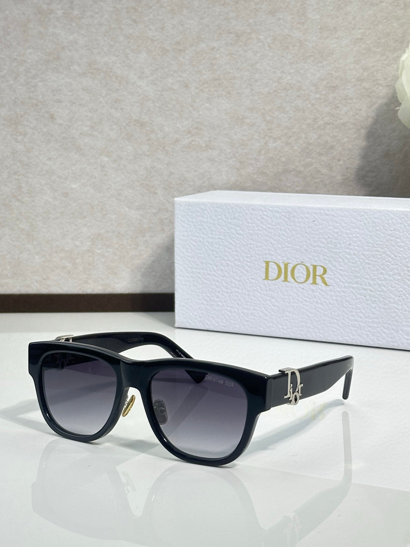 Dior sunglasses with black frames and dark lenses, silver-toned logo detail on the temple