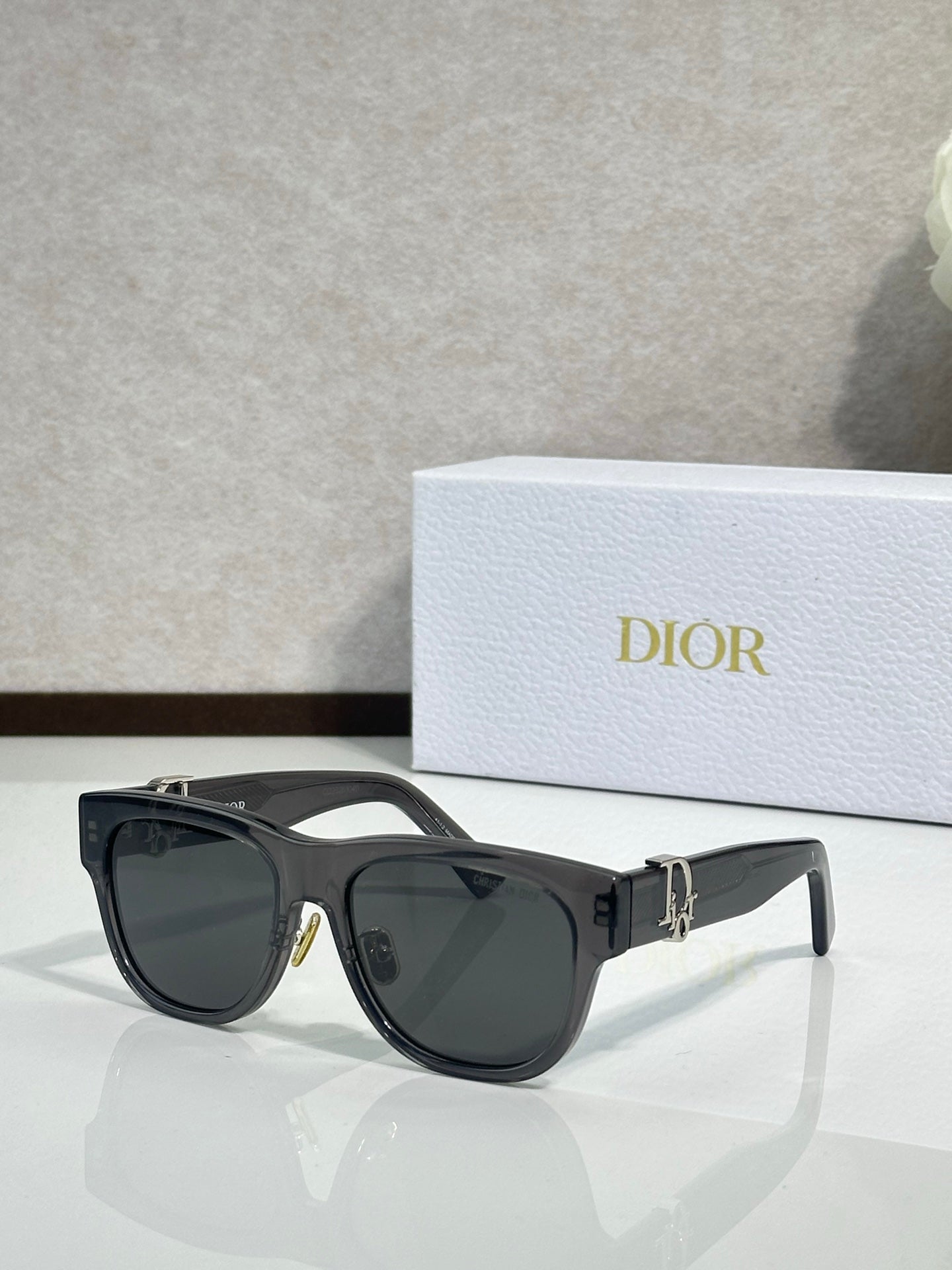 Dior sunglasses with black frames and dark lenses, featuring a gold side logo detail