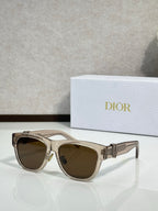 Dior sunglasses with tan frames and brown-tinted lenses, gold logo detail on the arm