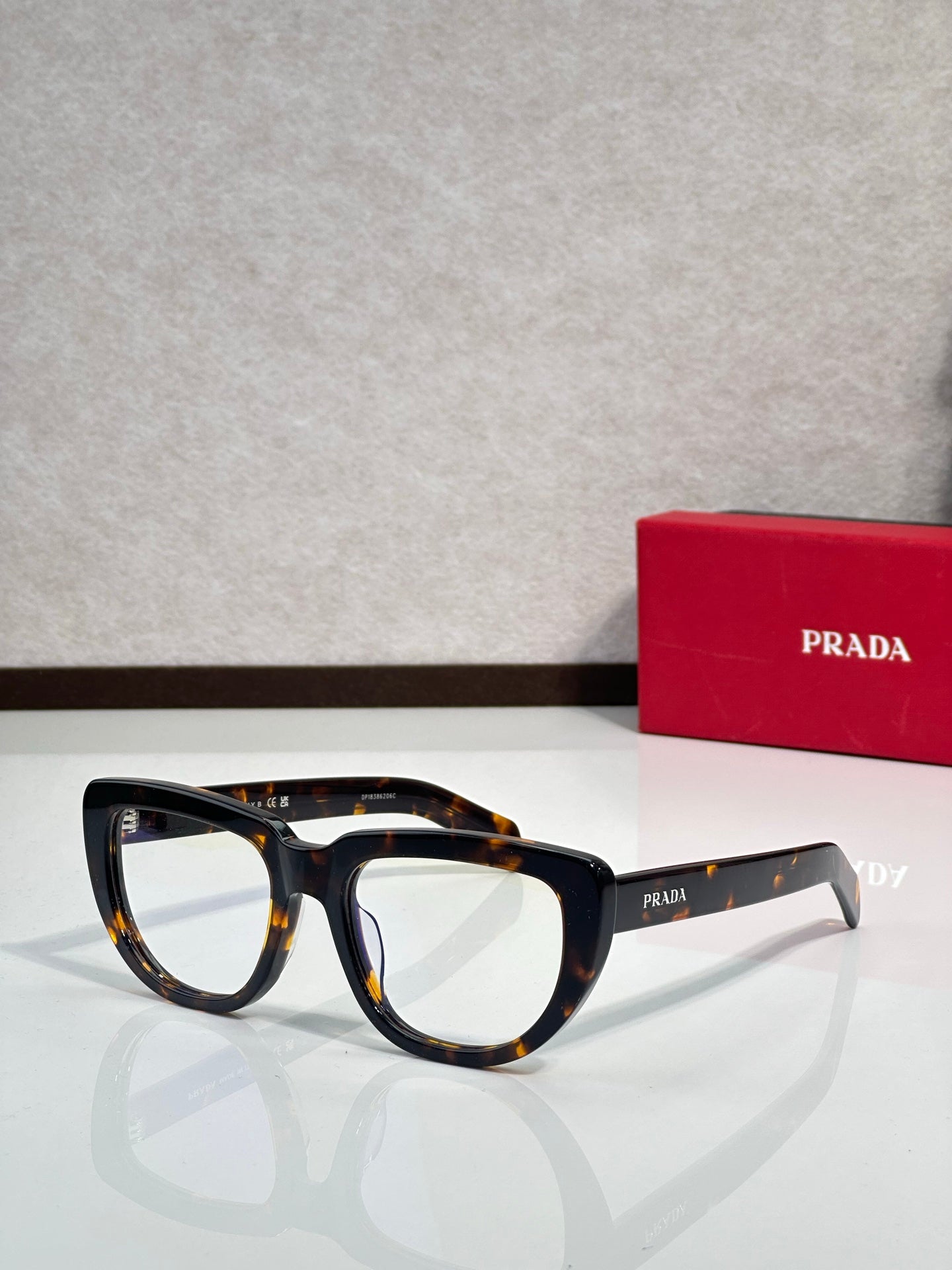 Prada sunglasses with dark tortoiseshell frames and light-gray arms, tinted lenses
