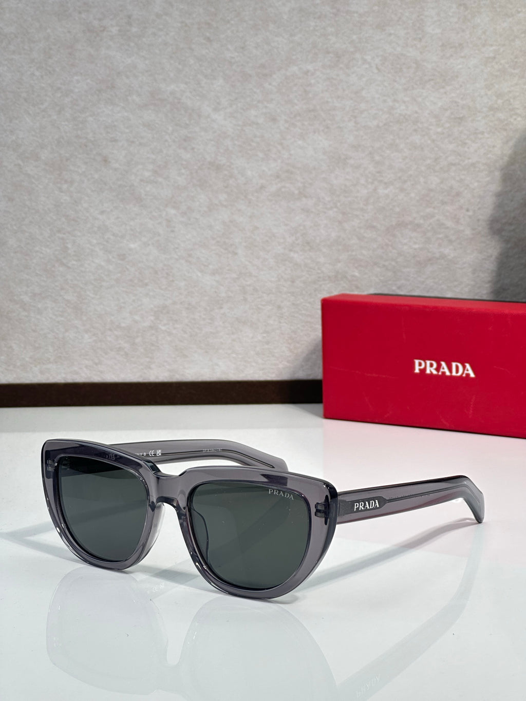 Prada sunglasses with dark gray frames and dark tinted lenses, side profile