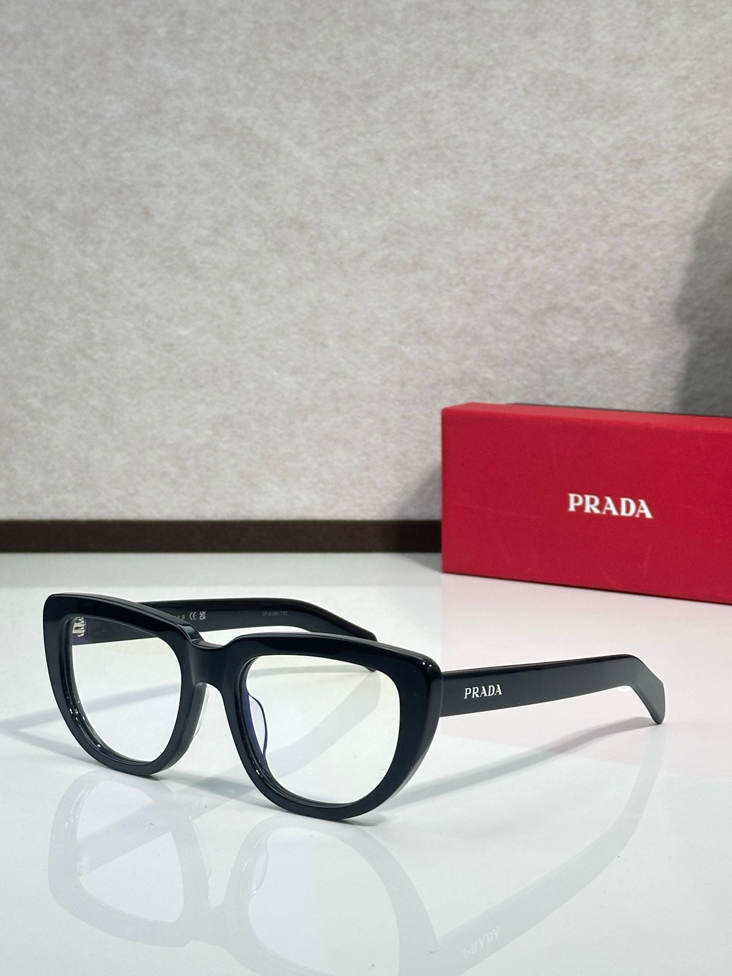 Prada sunglasses with black frames and light-gray arms, tinted lenses
