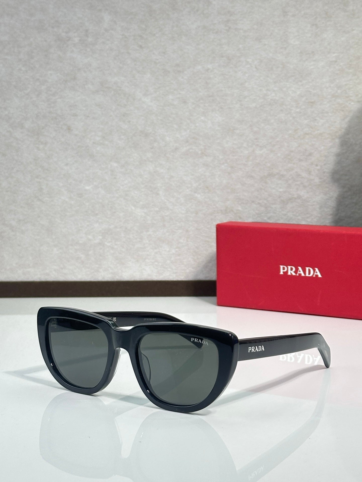 Prada sunglasses with black frames and dark tinted lenses, front view
