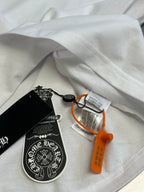 Folded white T-shirt with hang tag and orange security tag on fabric