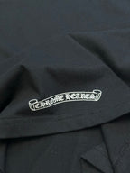 Black T-shirt with centered white logo patch across chest near hem