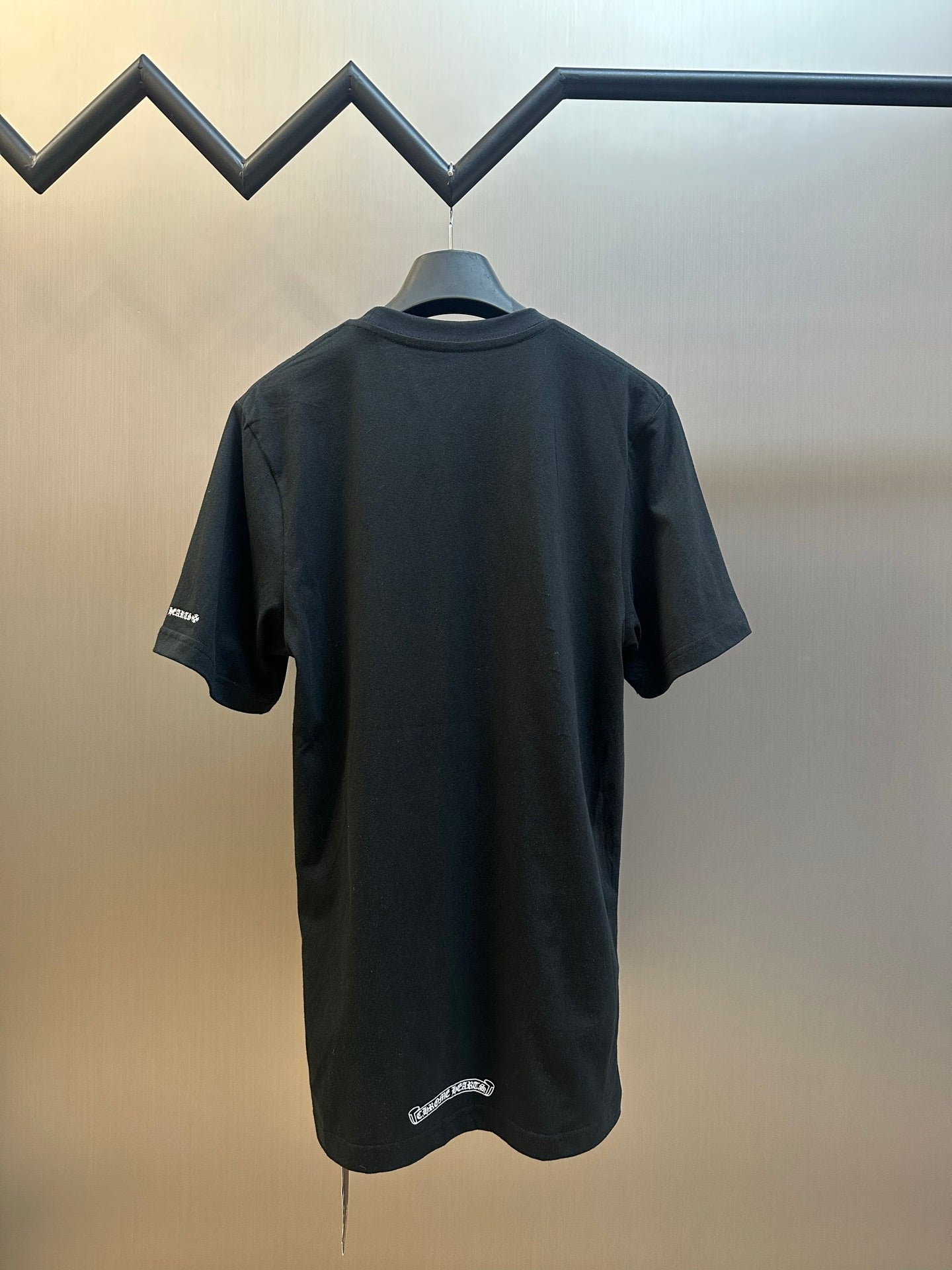 Black short-sleeve T-shirt back view with small logo detail at hem