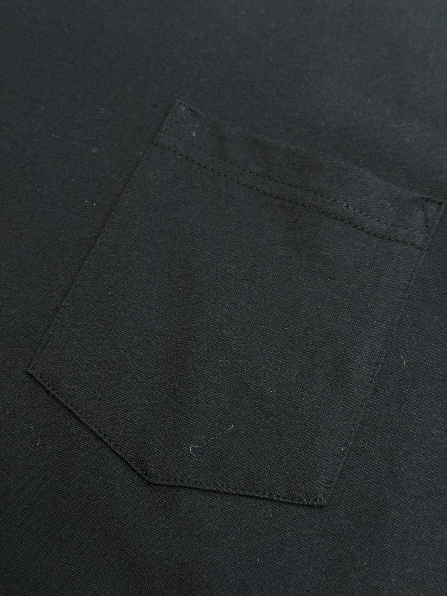 Black T-shirt with square chest pocket and visible topstitching