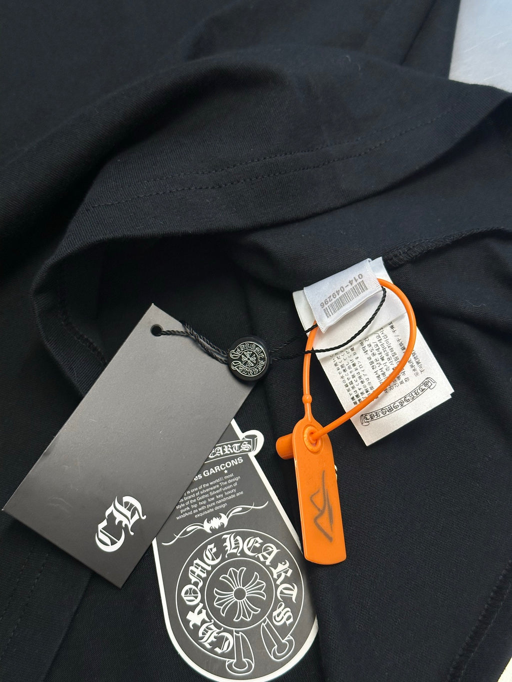 Black short-sleeve T-shirt with attached tags and orange hanging string