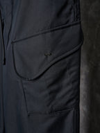 Dark pants with curved pocket flap and small embroidered logo