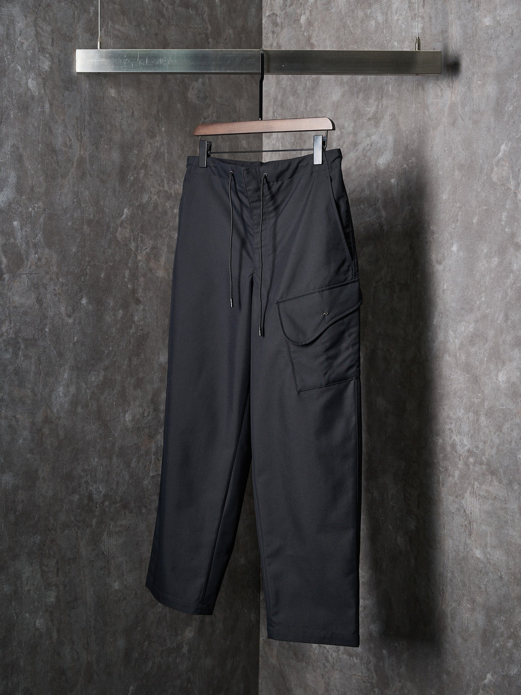 Dark wide-leg drawstring pants with front cargo-style pocket