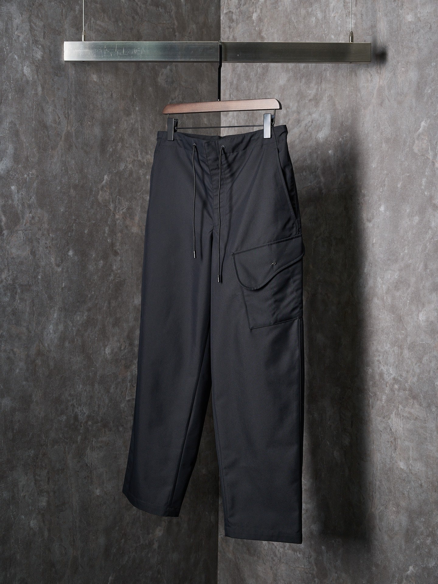Dark wide-leg drawstring pants with front cargo-style pocket
