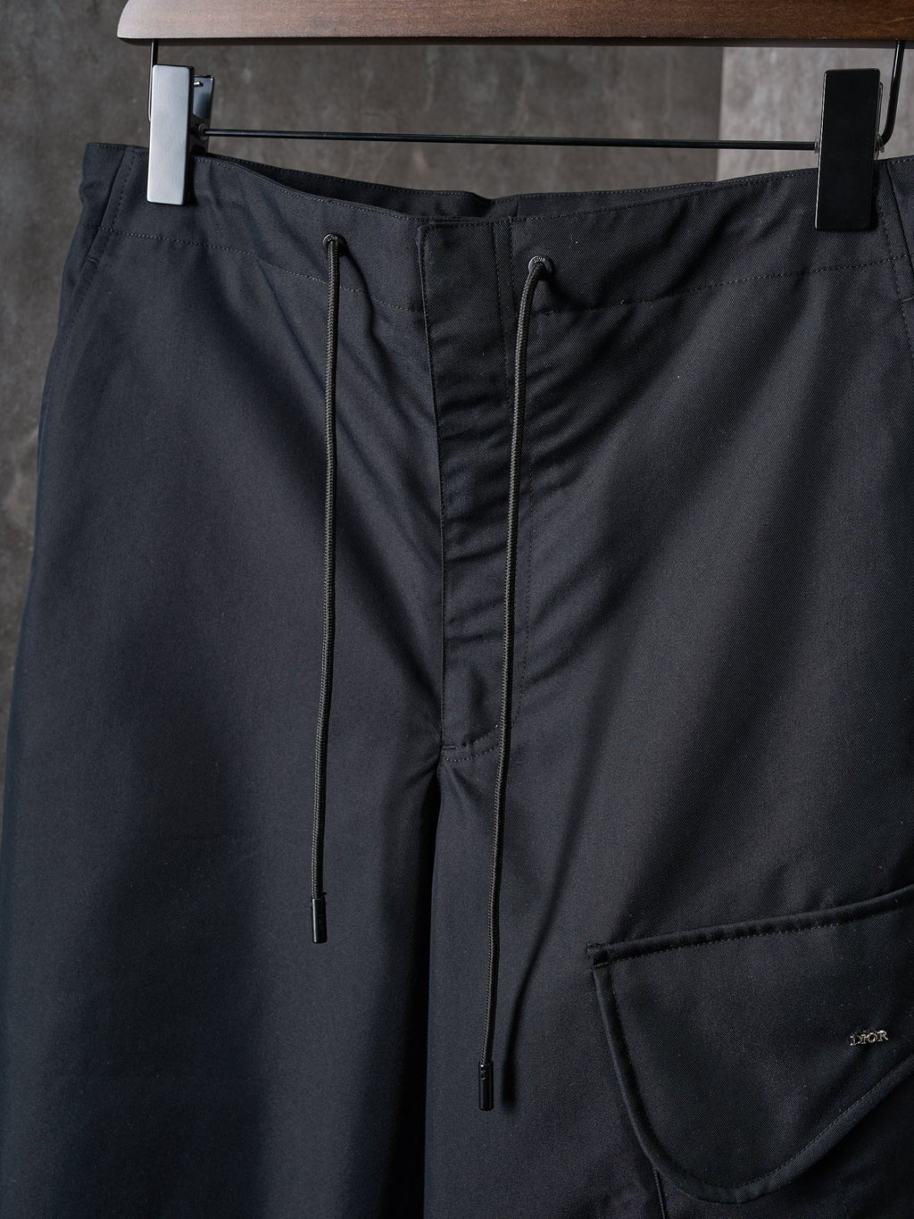 Dark pants waistband with drawstring ties and side pocket opening