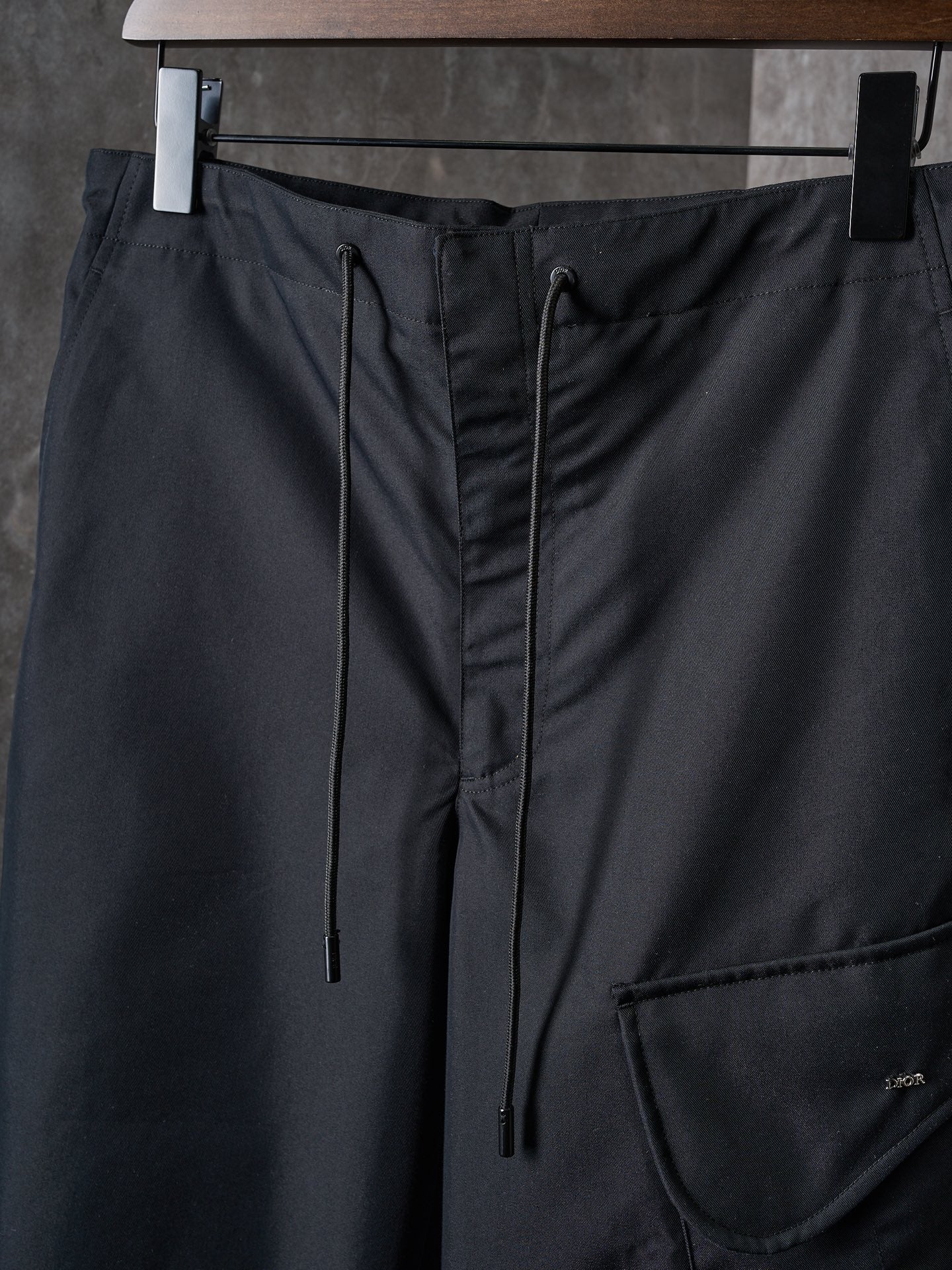 Dark pants waistband with drawstring ties and side pocket opening
