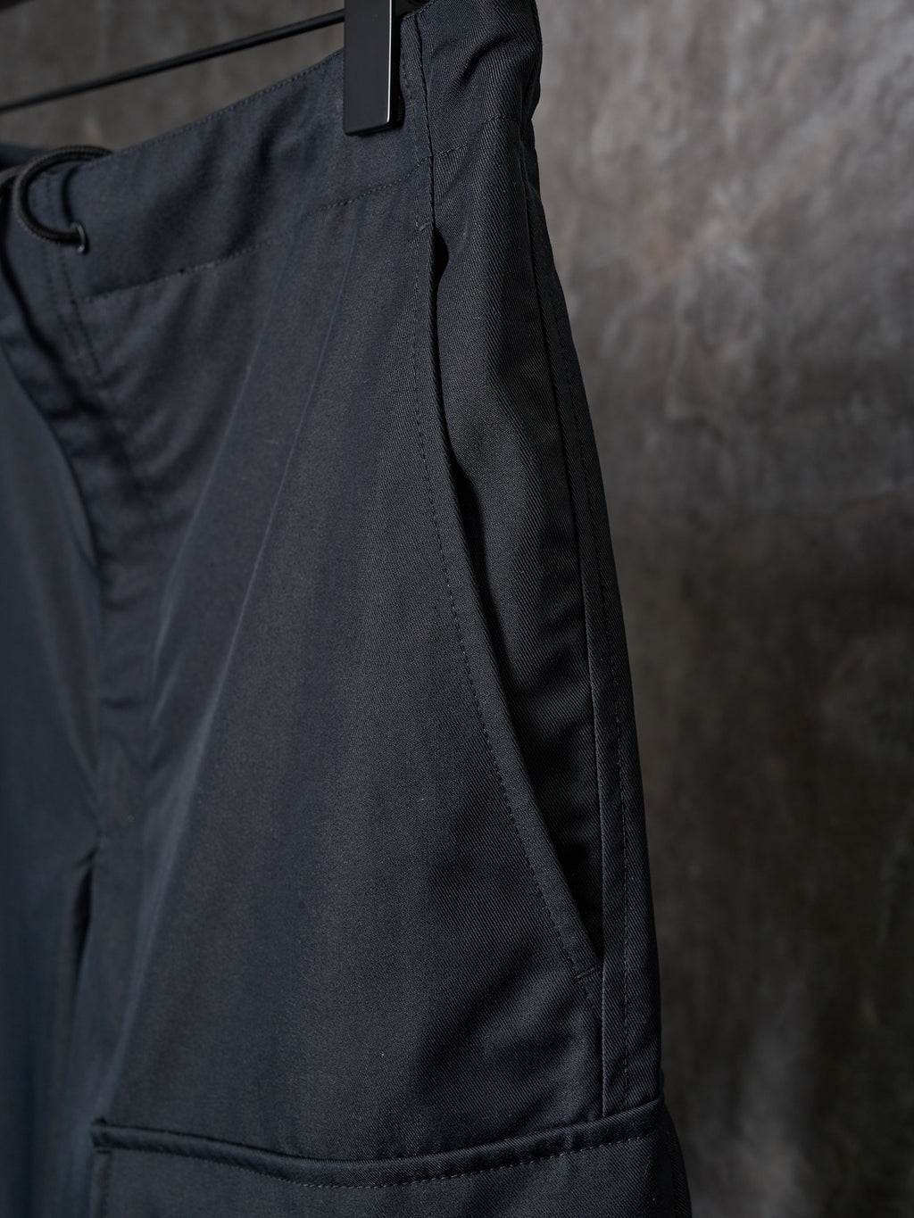 Dark drawstring pants with side seam and stitched panel