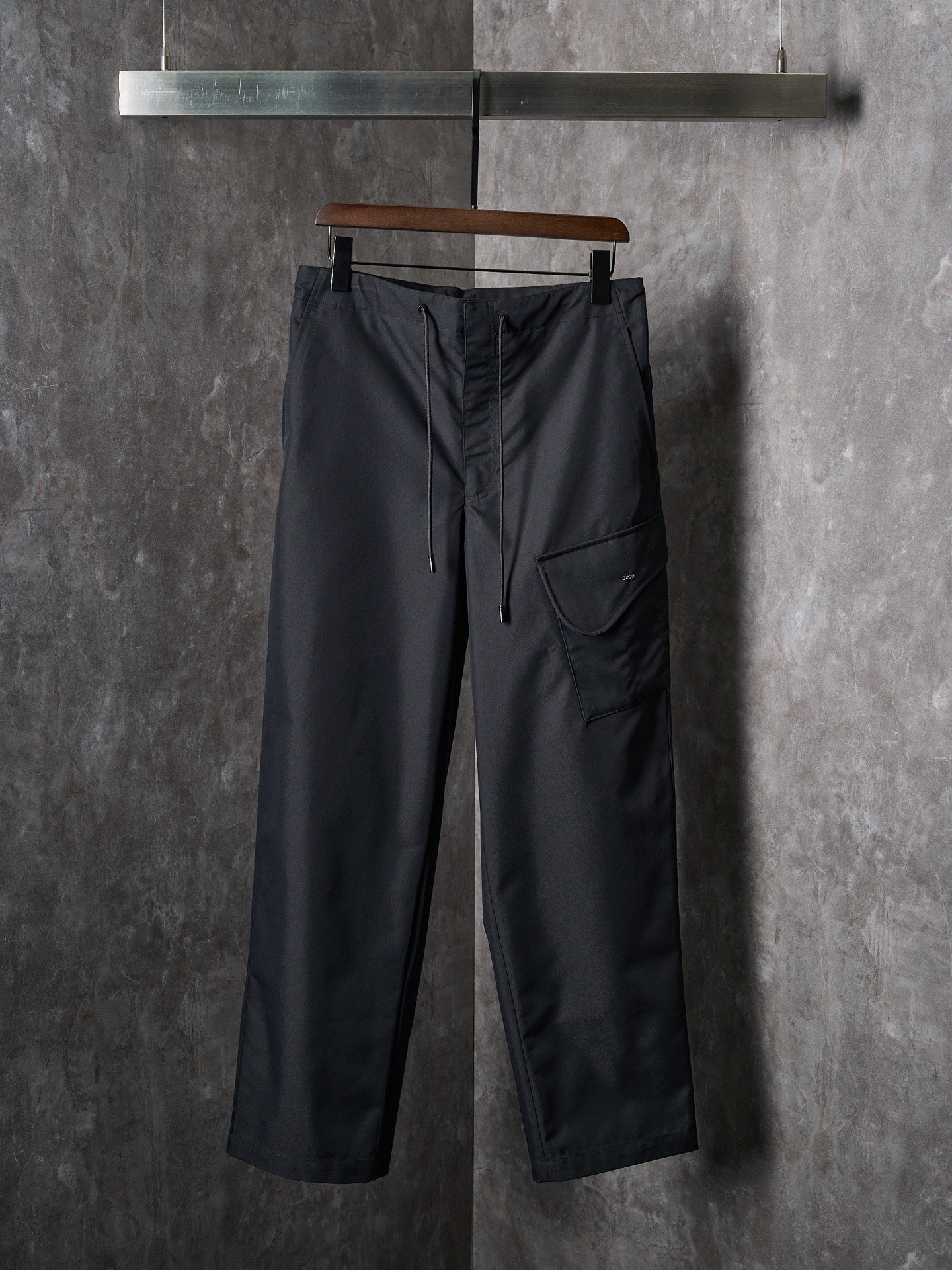 Dark drawstring pants with side pockets and front cargo pocket