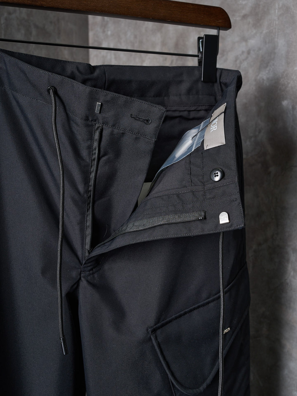 Dark cargo pants with front flap pocket and angled seam details