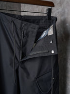 Dark cargo pants with front flap pocket and angled seam details
