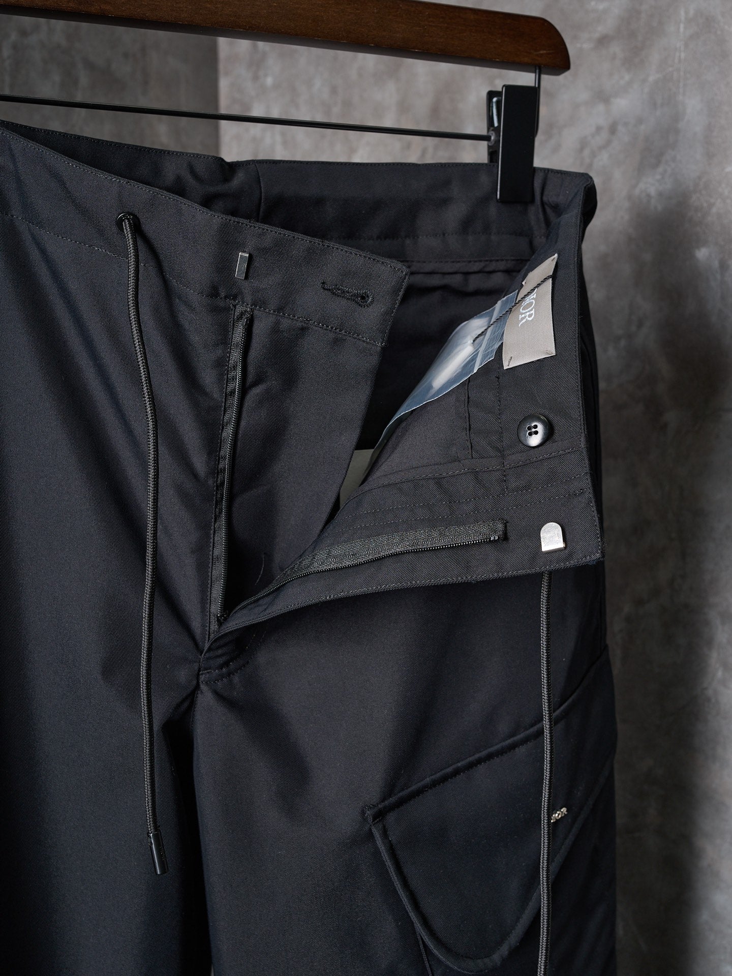 Dark cargo pants with front flap pocket and angled seam details