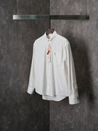 White button-up shirt with chest pocket, pointed collar, and long sleeves